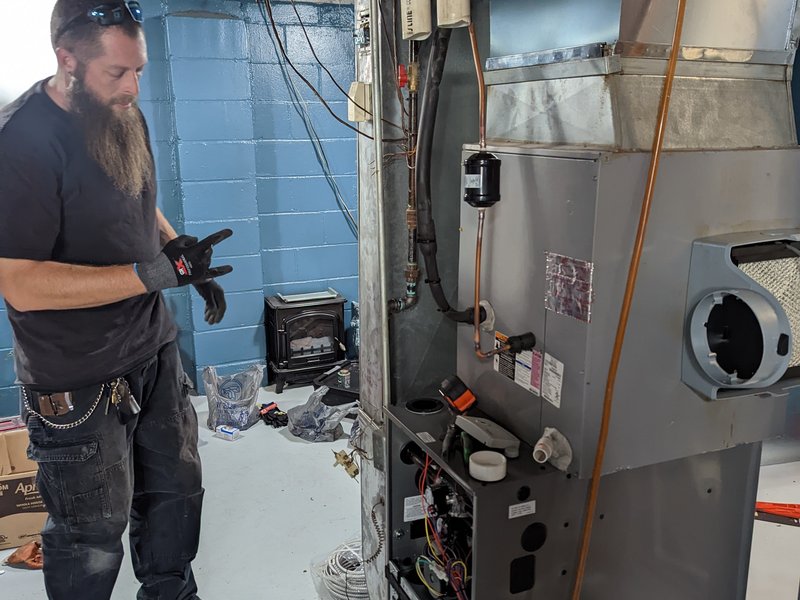 Americool technician checking HVAC controls and wiring
